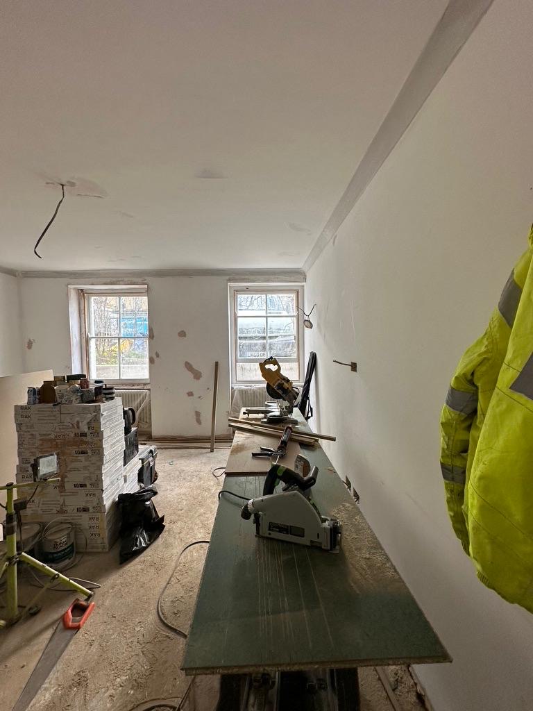 Reception room during first-fix, plastered walls with joinery workstation set up