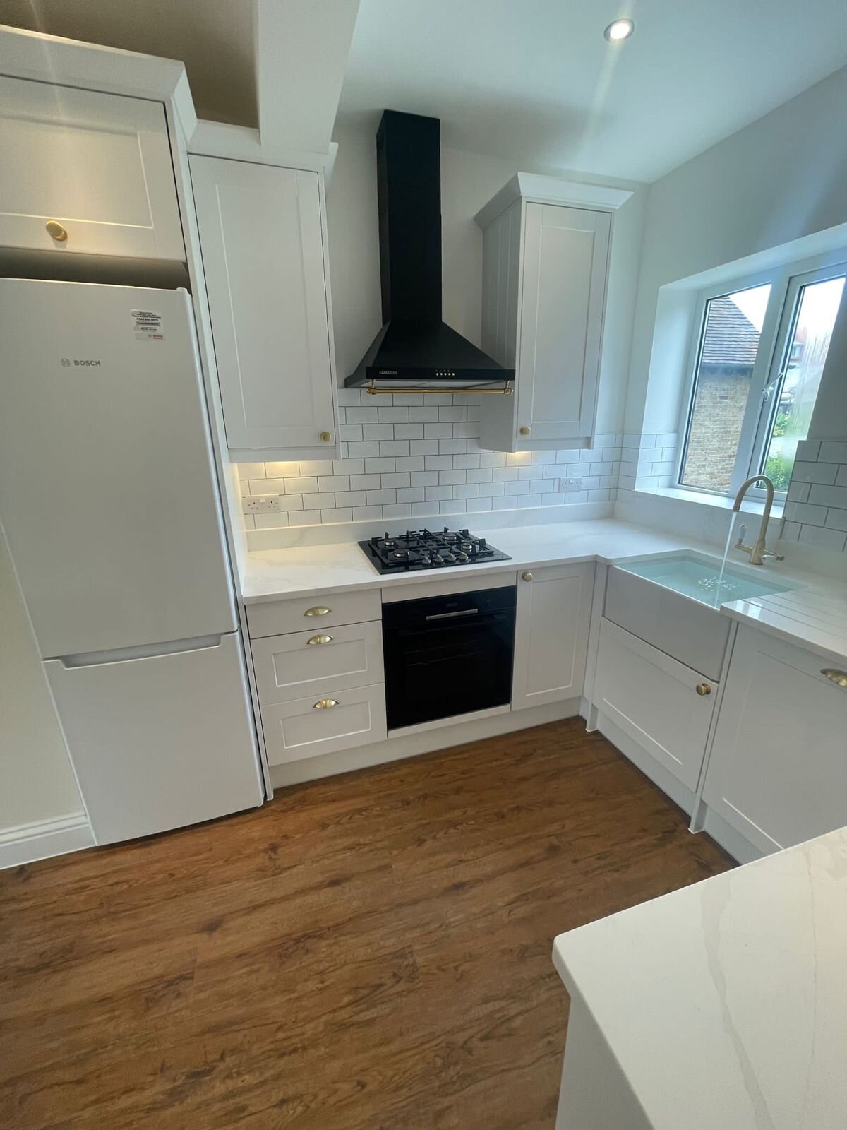 Painted shaker kitchen with tiled splashback and integrated hob