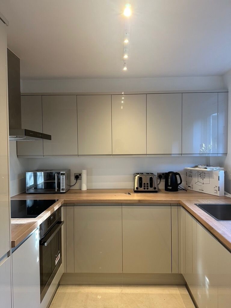 Warm timber worktop against handleless cream units, Croydon kitchen detail