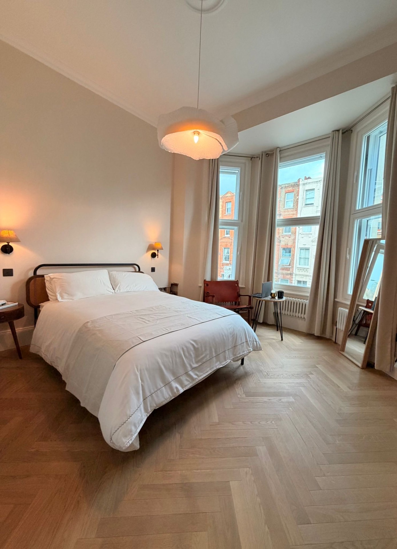 Principal bedroom with bay window, herringbone oak floor and sculptural pendant