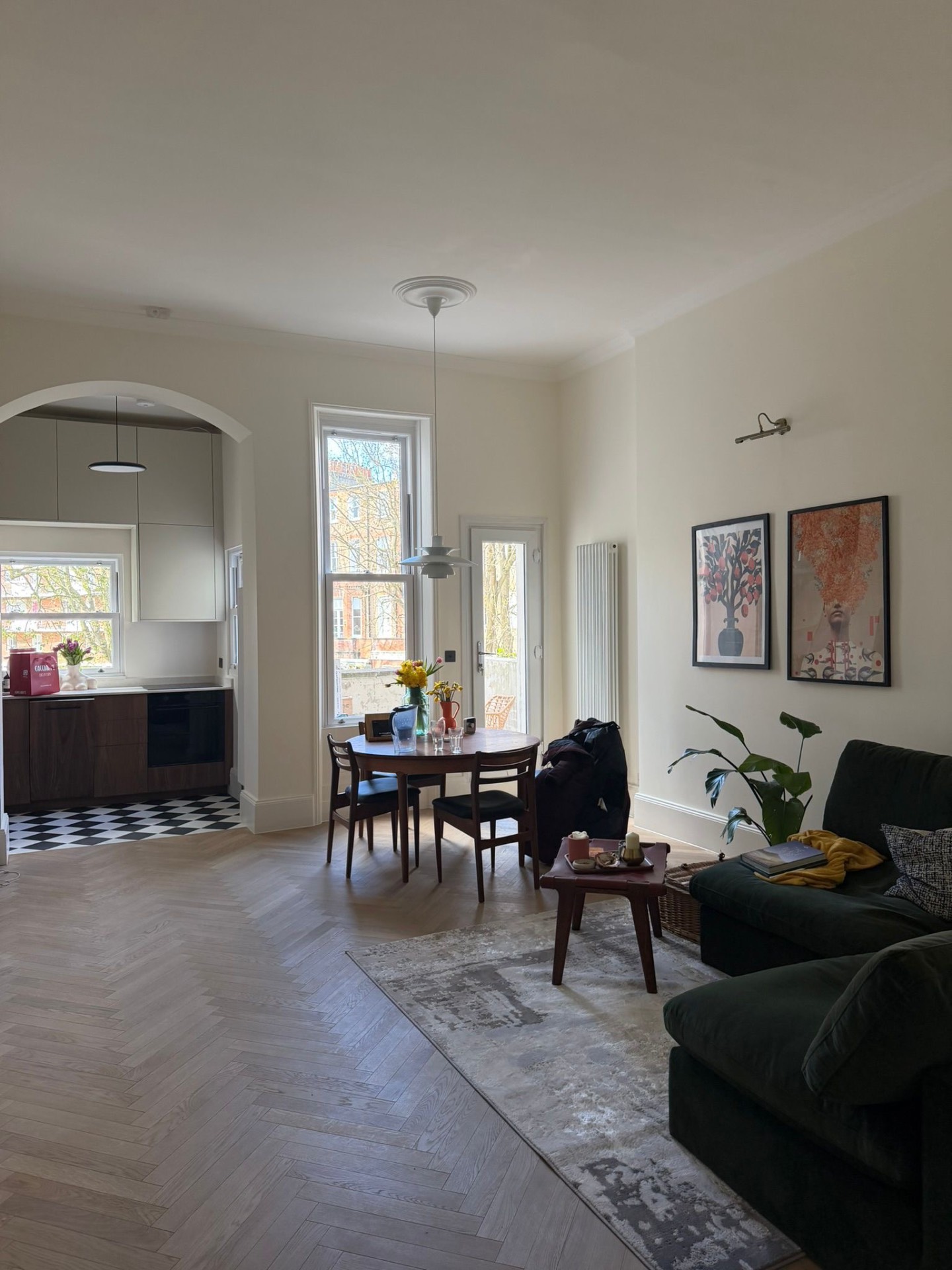 Open-plan living and dining with herringbone parquet, arched kitchen opening and period cornicing