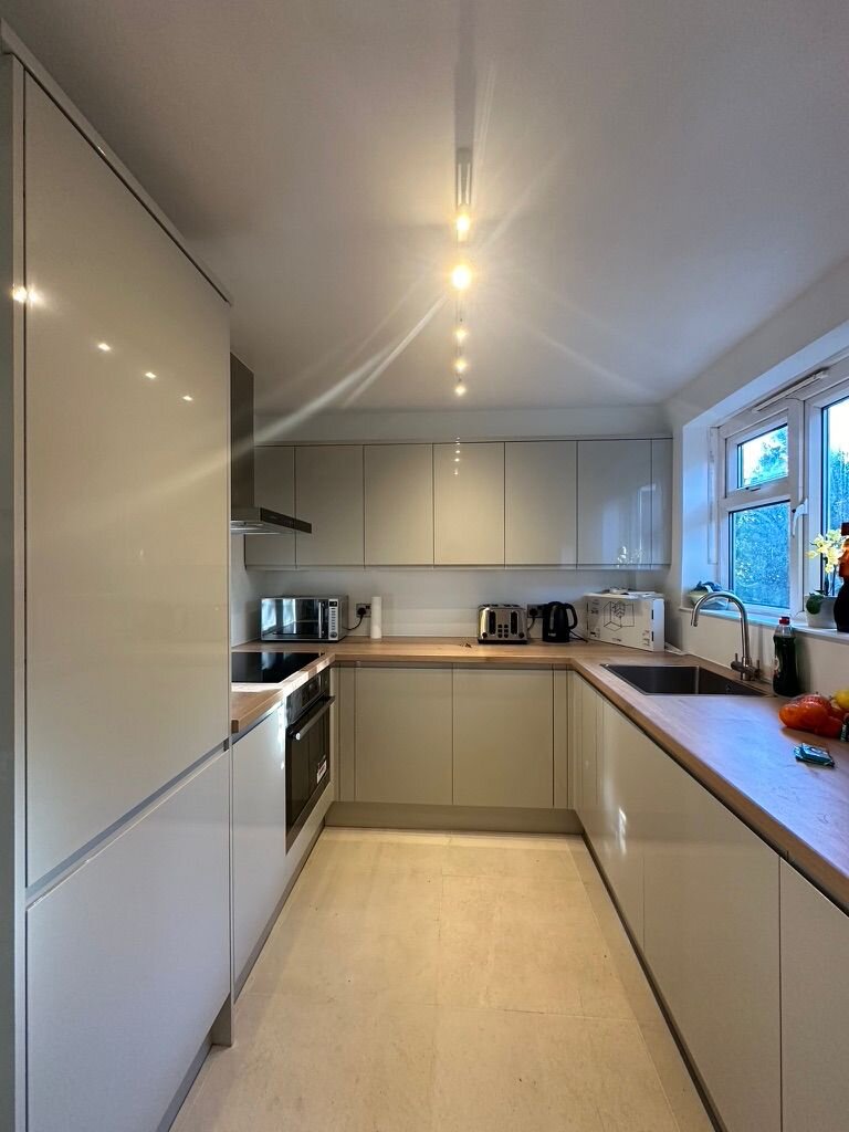 Handleless cream cabinetry and integrated appliances along the main run, Croydon kitchen renovation