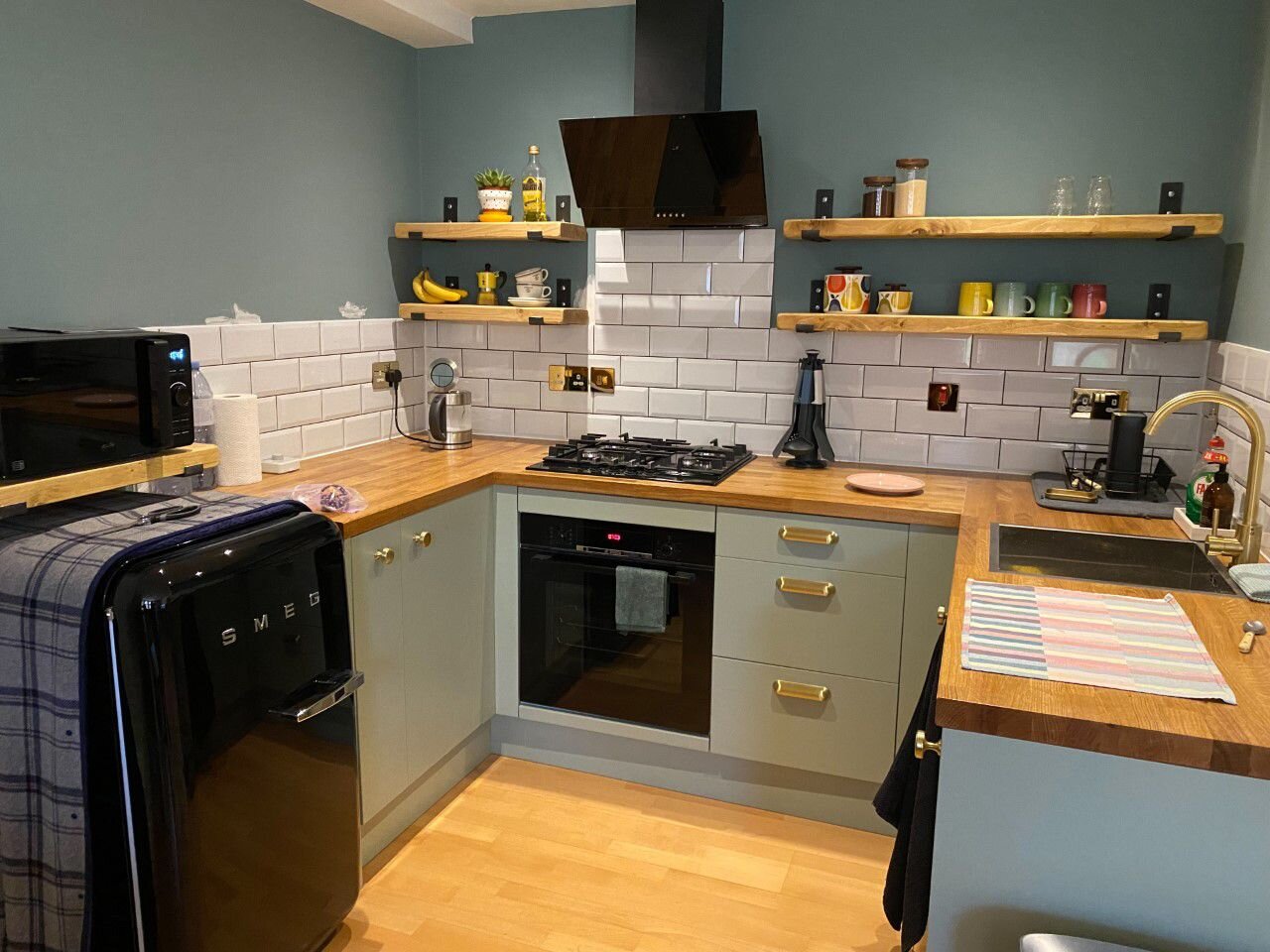 Open-plan handleless kitchen with full-height storage and quartz worktop